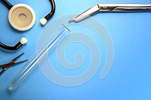 Medical background. Tools and objects of the doctor on a blue background. Phonendoscope, test tube, surgical scissors and clamp.