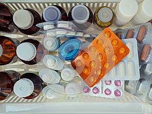 Medical background with various medicines. Bottles of tinctures and antiseptics, blister tablets and other medicines on the shelf