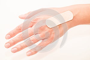 Medical band aid is glued to woman hand, selective focus