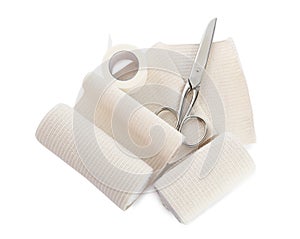 Medical bandage rolls, sticking plaster and scissors on white background, top view