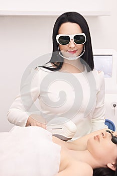 Medical beauty laser cosmeology procedure. Young female at salon. Professional doctor. Woman skincare technology. Hair removal