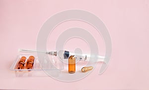 Medical bottles made of brown glass with a medicinal solution on a pink background