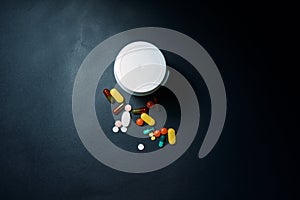 Medical bottles and medication pills spilling out on to pastel blue background. Top view with copy space. Healthcare, pharmacy