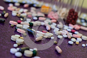 Medical bottles and medication pills spilling out on to purple background