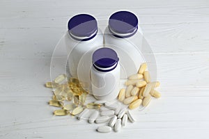 Medical bottles and pills on white wooden table