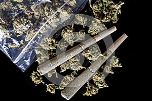 Medical cannabis joints and buds scattered from package black above