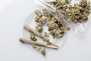 Medical cannabis joints and buds scattered from package white above