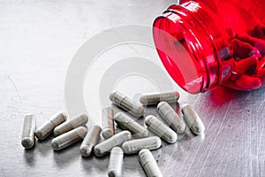 Medical capsule from red bottle for danger of drug overdose heath care concept photo
