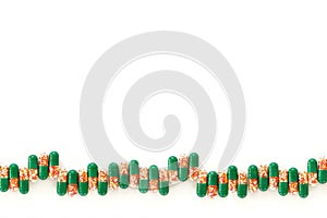 Medical capsules with colored granules in a row on a white background.