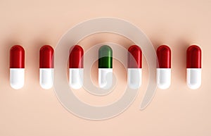 Medical capsules in a line on beige background