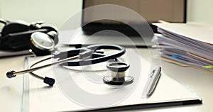 Medical card pen and stethoscope on table closeup