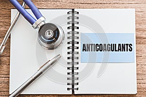 Medical card with stethoscope ant text ANTICOAGULANTS on wooden desk