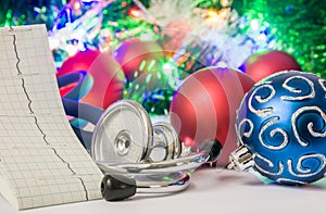 Medical cardiology Christmas and New Year photo - stethoscope and electrocardiogram tape are located near balls for Christmas tree