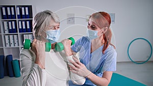 medical care at home during Covid 19, portait physiotherapist and active senior patient in protective masks, woman