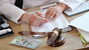 Medical clinic lawyer works with health insurance and financial documents at his desk.