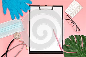 Medical clipboard, stethoscope, monstera sheet, goggles and face shield on a pink background. Medical banner template with copy