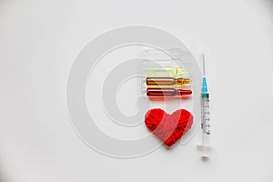 Medical colorful vials for injection syringe and red heart on a white background. Healthy heart. lifestyle. Copy space