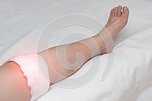 Medical compress on the knee joint in a woman, treatment of the knee with traditional medicine, close-up, inflammation photo