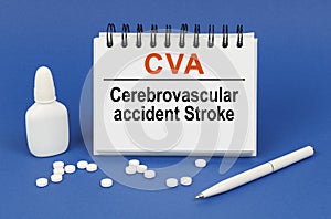 On a blue background, a pen, tablets and a notepad with the inscription - CVA Cerebrovascular accident Stroke photo