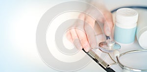 Medical concept on a blue background. stethoscope, pills, notepad, sheet of paper, pen. Space for text