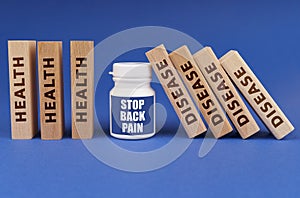 Medical concept. On a blue background, wooden dies, a white jar with the inscription - STOP BACK PAIN