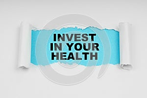 In the middle of a white sheet in space on a blue background the inscription - INVEST IN YOUR HEALTH