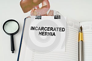 On the table there is a magnifying glass and a notepad with the inscription - Incarcerated hernia