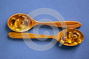 Medical concept. Wooden spoons with pills isolated on beautiful blue background. Web banner with a copy space