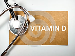 Medical concept.Word VITAMIN D on brown paper with stethoscope.