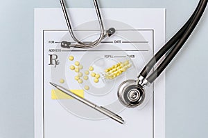 Medical concept. Yellow pills with stethoscope  pills  notepad  medical prescription  pen on the doctor\'s desktop