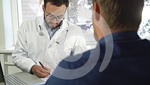 Medical consultation - doctor and patient sitting by the table