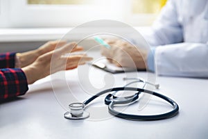 Medical consultation - doctor talking to patient in clinic office