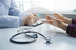 Medical consultation - patient in clinic office asks the doctor for advice