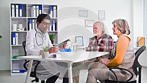 medical consultation, young black doctor examines an elderly couple in hospital office