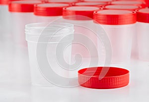 Medical container for the collection of tests with an open inverted lid on the background of other containers. Concept