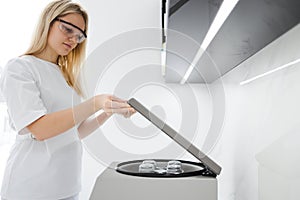 Medical cosmetologist opens a plasma-lifting centrifuge.