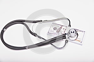 Medical cost rising, stethoscope on dollar banknote money. concept of health care costs, finance, health insurance funds