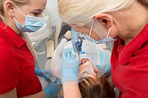 Medical dentist team in dental office with female patient preparing for treatment. dentist and assistent in process