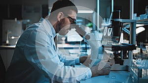 Medical Development Laboratory: Caucasian Female Scientist Looking Under Microscope, Analyzes Petr