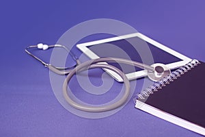Medical device for listening stethoscope, tablet, copybook on a blue background, medical research and healthcare concept, top view