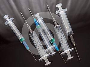 Medical disposable syringes with needles on a dark surface