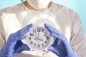 Medical woman doctor with an alarm clock in her hand . health care concept