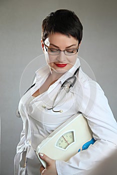 Medical doctor with body scales. Weight problem.