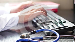 Medical doctor hands typing on computer keyboard