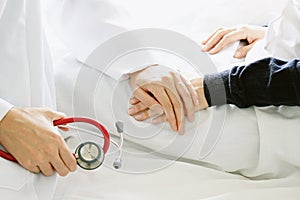 Medical doctor holding patient`s hands and comforting her with care.