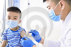 Medical Doctor injecting child with vaccine at clinic or hospital photo