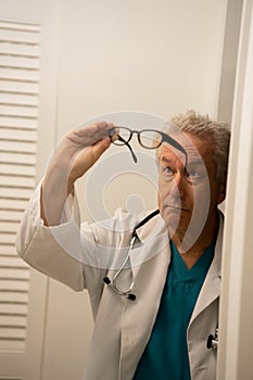 Medical doctor looking at his glasses