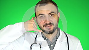 Medical doctor man looking at camera and asks to call him. Green screen background