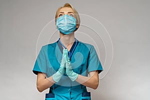 Medical doctor nurse woman wearing protective mask and latex gloves - praying nad hoping gesture