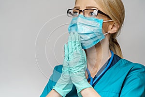 Medical doctor nurse woman wearing protective mask and latex gloves - praying nad hoping gesture